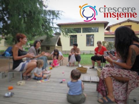 Un gruppo di genitori e bambini ritratti durante un incontro del progetto Crescere insieme