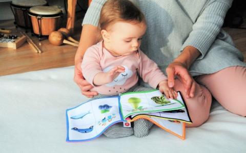 donna che illustra a un neonato un libro