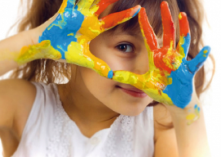 immagine di una bambina che mostra le mani imbrattate datanti colori