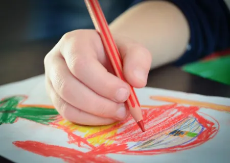 immagine che presenta la mano di un bambino che disegna